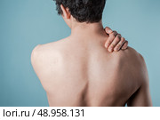 Young man is in pain and is massaging his sore neck. Стоковое фото, агентство Ingram Publishing / Фотобанк Лори