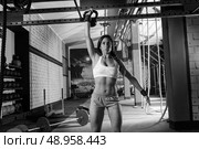 brunette girl at gym lifting a kettlebell weightlifting workout. Стоковое фото, агентство Ingram Publishing / Фотобанк Лори