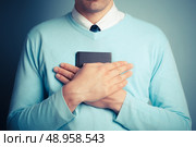 A young man is clutching a small notebook. Стоковое фото, агентство Ingram Publishing / Фотобанк Лори