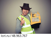 A cowboy builder with a big tool box is pulling silly faces and gesturing. Стоковое фото, агентство Ingram Publishing / Фотобанк Лори