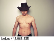 Sexy shirtless young cowboy posing against a green and white background. Стоковое фото, агентство Ingram Publishing / Фотобанк Лори