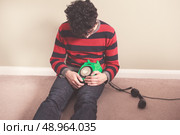 Sad man sitting on the floor has received bad news on the telephone. Стоковое фото, агентство Ingram Publishing / Фотобанк Лори
