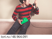 Angry young man is screaming at the telephone. Стоковое фото, агентство Ingram Publishing / Фотобанк Лори