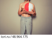 Athletic young man is holding a beach ball. Стоковое фото, агентство Ingram Publishing / Фотобанк Лори