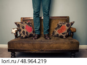 Man standing on sofa. Стоковое фото, агентство Ingram Publishing / Фотобанк Лори