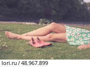 The bare legs of a young woman as she is relaxing on the grass in a park. Стоковое фото, агентство Ingram Publishing / Фотобанк Лори