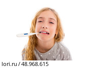 blond girl with thermometer and flu cold in pyjama and funny face. Стоковое фото, агентство Ingram Publishing / Фотобанк Лори