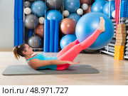 Ab exercise woman swiss ball leg lifts Pilates workout abs at gym. Стоковое фото, агентство Ingram Publishing / Фотобанк Лори