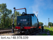 Осташков Тверская область Россия-25.08.2024. РЕТРОПОЕЗД «СЕЛИГЕР» БОЛОГОЕ – ОСТАШКОВ на паровой тяге. Тендер паровоза заправляют водой из гидроколонки через "хобот" и заправочный люк на железнодорожной станции Осташков. Ostashkov Tver region, Russia-08/25/2024. RETROPOEZD "SELIGER" BOLOGOE – OSTASHKOV on steam traction. The locomotive's tender is filled with water from a hydraulic column through a "trunk" and a filling hatch at the Ostashkov railway station. Редакционное фото, фотограф Мария / Фотобанк Лори