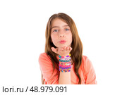Loom rubber bands bracelets blond kid girl blowing hand on white background. Стоковое фото, агентство Ingram Publishing / Фотобанк Лори
