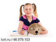Blond kid girl student with hedgehog book on white background. Стоковое фото, агентство Ingram Publishing / Фотобанк Лори