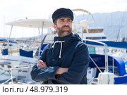 Sailor man in marina port with boats background and blue cap. Стоковое фото, агентство Ingram Publishing / Фотобанк Лори