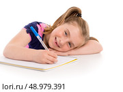 Blond kid indented girl student with spiral notebook in pupil desk. Стоковое фото, агентство Ingram Publishing / Фотобанк Лори