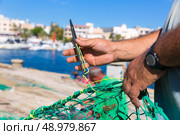Majorca Cala Ratjada beach Rajada fisherman sewing fishing net. Стоковое фото, агентство Ingram Publishing / Фотобанк Лори