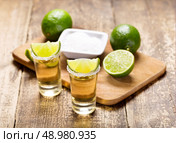 glasses of tequila with lime on wooden table. Стоковое фото, агентство Ingram Publishing / Фотобанк Лори