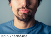 A young man with a beard is pulling silly faces. Стоковое фото, агентство Ingram Publishing / Фотобанк Лори