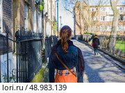 A young woman is walking on a cobbled street of Georgian terraces. Стоковое фото, агентство Ingram Publishing / Фотобанк Лори