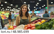 A customer smiling at cashier during checkout, grocery items arranged on conveyor belt, soft overhead lighting creating comfortable atmosphere. Стоковое AI-видео, аниматор Sergey Grishin / Фотобанк Лори