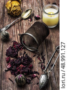 tea strainer and different varieties of tea leaves on wooden background.The toned image. Стоковое фото, агентство Ingram Publishing / Фотобанк Лори