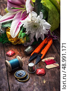 sewing accessories with a bouquet of fresh flowers.the image is tinted in vintage style. Стоковое фото, агентство Ingram Publishing / Фотобанк Лори