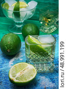 glass alcoholic drink and lime fruits on wooden texture.Selective focus. refreshing cocktail made of rum and lime with ice. Стоковое фото, агентство Ingram Publishing / Фотобанк Лори