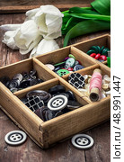 wooden box with buttons and thread on the background of bouquet of white tulips. image is tinted in vintage style. thread and buttons. Стоковое фото, агентство Ingram Publishing / Фотобанк Лори