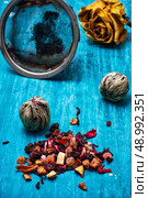 dried fragrant tea leaves on wooden turquoise background. tea brew two types amid the tea strainer. Стоковое фото, агентство Ingram Publishing / Фотобанк Лори