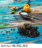 Tea leaves for brewing,tea spoon and dried yellow rose.The image is tinted in vintage style. Стоковое фото, агентство Ingram Publishing / Фотобанк Лори