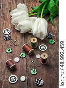 sewing accessories with a bouquet of fresh flowers.the image is tinted in vintage style. Стоковое фото, агентство Ingram Publishing / Фотобанк Лори