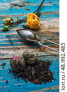 Tea leaves for brewing,tea spoon and dried yellow rose.The image is tinted in vintage style. Стоковое фото, агентство Ingram Publishing / Фотобанк Лори