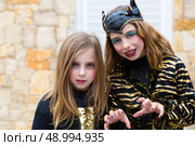 Halloween kid sister girls costume scaring gesture in outdoor. Стоковое фото, агентство Ingram Publishing / Фотобанк Лори
