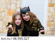 Halloween kid sister girls costume scaring gesture in outdoor. Стоковое фото, агентство Ingram Publishing / Фотобанк Лори