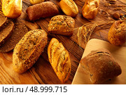 Bread fresh varied mix on golden rustic wood golden table. Стоковое фото, агентство Ingram Publishing / Фотобанк Лори