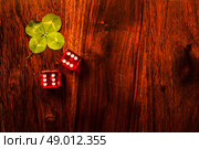 Two red dices with a luckycharm four-leaf clover. Стоковое фото, агентство Ingram Publishing / Фотобанк Лори