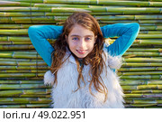 Kid girl relaxed in green canes background in autumn winter. Стоковое фото, агентство Ingram Publishing / Фотобанк Лори