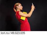 Blond fashion woman selfie photo in smartphone on black background and red dress. Стоковое фото, агентство Ingram Publishing / Фотобанк Лори