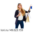 Blond shopaholic woman with bags coffee and smartphone stopping taxi finger. Стоковое фото, агентство Ingram Publishing / Фотобанк Лори