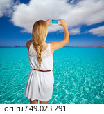 Blond braid tourist girl smartphone photo beach of Formentera photomount. Стоковое фото, агентство Ingram Publishing / Фотобанк Лори