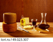 Manchego cheese from Spain with olive oil and red wine on wood. Стоковое фото, агентство Ingram Publishing / Фотобанк Лори