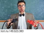 Nerd electronics technician retro teacher silly expression working battery clamps. Стоковое фото, агентство Ingram Publishing / Фотобанк Лори