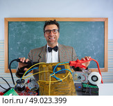 Nerd electronics technician retro teacher silly expression with big battery clamps in pcb. Стоковое фото, агентство Ingram Publishing / Фотобанк Лори