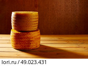 Manchego cheese from Spain in wooden table stacked. Стоковое фото, агентство Ingram Publishing / Фотобанк Лори