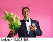 Nerd man with lipstick marks on face in Valentines Day and flowers. Стоковое фото, агентство Ingram Publishing / Фотобанк Лори