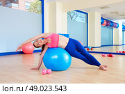 Pilates woman fitball side bend exercise workout at gym indoor. Стоковое фото, агентство Ingram Publishing / Фотобанк Лори