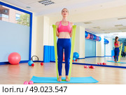 Pilates woman biceps rubber band exercise workout at gym indoor. Стоковое фото, агентство Ingram Publishing / Фотобанк Лори