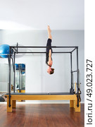 Pilates woman in cadillac acrobatic upside down balance reformer exercise at gym. Стоковое фото, агентство Ingram Publishing / Фотобанк Лори