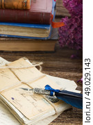 feather pen . old postage with books  and blue  feather pen. Стоковое фото, агентство Ingram Publishing / Фотобанк Лори