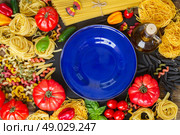 Raw pasta with ingridients and blue plate. Raw pasta with ingridients and copy space on blue plate. Стоковое фото, агентство Ingram Publishing / Фотобанк Лори