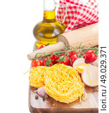 Tonarelli raw pasta. Tonarelli  raw pasta with  tomato and olive oil isolated on white background. Стоковое фото, агентство Ingram Publishing / Фотобанк Лори