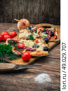flavorful homemade pizza with bacon. hunk of delicious meat pizza with bacon and olives on the background of the vegetables.The image is tinted. Стоковое фото, агентство Ingram Publishing / Фотобанк Лори